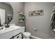 Charming half bathroom with modern vanity, round mirror, and decorative wall shelves at 975 Alta St, Lochbuie, CO 80603