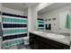Well-lit bathroom featuring dual sinks, modern fixtures, and a shower with a stylish curtain at 975 Alta St, Lochbuie, CO 80603