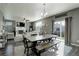 Open-concept dining area featuring a large table, chairs, a bench and a sliding glass door at 975 Alta St, Lochbuie, CO 80603