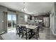 Open dining area with view to kitchen, large table, and sliding glass door at 975 Alta St, Lochbuie, CO 80603