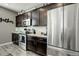 Well-lit kitchen features stainless steel appliances, dark cabinetry and bright countertops at 975 Alta St, Lochbuie, CO 80603