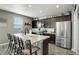 Modern kitchen featuring a large island, stainless steel appliances, and dark wood cabinets at 975 Alta St, Lochbuie, CO 80603
