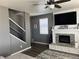 Inviting living room features a fireplace, ceiling fan, and staircase access at 975 Alta St, Lochbuie, CO 80603