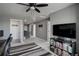 Open loft area with carpet, ceiling fan, and television, perfect for relaxing or entertaining at 975 Alta St, Lochbuie, CO 80603