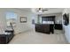 Bright main bedroom with carpet, ceiling fan, and dark wood furniture at 975 Alta St, Lochbuie, CO 80603