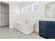 Bright bathroom featuring a freestanding tub, blue vanity, and modern fixtures at 39441 Stockton Cir, Elizabeth, CO 80107