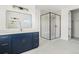 Stylish bathroom with a black framed shower, blue vanity, and modern lighting at 39441 Stockton Cir, Elizabeth, CO 80107