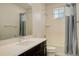 Modern bathroom with a single sink vanity, a window, and a shower-tub combo with tile surround at 11063 Shining Star Cir, Parker, CO 80134