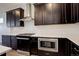 Close-up of kitchen with stainless steel appliances, dark cabinets, and tile backsplash at 11063 Shining Star Cir, Parker, CO 80134