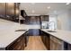 Stylish kitchen featuring stainless steel appliances, dark cabinets, and white backsplash at 11063 Shining Star Cir, Parker, CO 80134