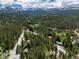 Aerial view of mountain community surrounded by lush green forest and snow-capped mountain range at 384 Blue Ridge Rd, Breckenridge, CO 80424