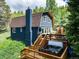 Rear exterior of barn style home showing chimney, hot tub on the deck, and access stairs at 384 Blue Ridge Rd, Breckenridge, CO 80424