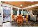 Dining room and kitchen with wood ceiling, access to outdoor deck and views of the forest at 384 Blue Ridge Rd, Breckenridge, CO 80424