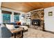Comfortable living room with stone fireplace, wood ceiling, bright natural light, and neutral color palette at 384 Blue Ridge Rd, Breckenridge, CO 80424