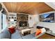 Cozy living room features a stone fireplace, wood ceiling, comfortable seating, and a large TV at 384 Blue Ridge Rd, Breckenridge, CO 80424