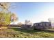Spacious backyard with a single-story home, detached building, and green grass at 6190 Ivy St, Commerce City, CO 80022