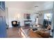 Sun-filled living room with hardwood floors, modern furnishings, and an open-concept design leading to the kitchen at 6190 Ivy St, Commerce City, CO 80022