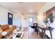 Bright living room with hardwood floors, modern decor, and an open view to the adjacent bathroom and kitchen at 6190 Ivy St, Commerce City, CO 80022