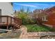 Lush backyard with brick pathway, manicured lawn, garden area, and quaint wooden staircase at 1239 N Lafayette St, Denver, CO 80218