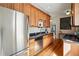 Well-lit kitchen with stainless steel appliances, wood cabinets, granite countertops, and hardwood floors at 1239 N Lafayette St, Denver, CO 80218
