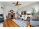 Bright living room featuring a decorative brick fireplace, hardwood floors, stylish furnishings, and a ceiling fan at 1239 N Lafayette St, Denver, CO 80218