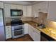 Kitchen featuring granite countertops, stainless steel appliances, and tile backsplash at 2597 S Dillon St, Aurora, CO 80014