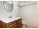 Small bathroom features a vanity with a round mirror above and a toilet next to it at 6579 Ingalls St, Arvada, CO 80003