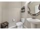 A simple half bathroom showcases a pedestal sink, elegant fixtures, and a decorative mirror adding style at 7310 Blue Water Dr, Castle Rock, CO 80108