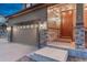 Welcoming entrance with warm lighting, a stylish front door, and attractive stone detailing at 7310 Blue Water Dr, Castle Rock, CO 80108