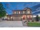Charming two-story home featuring a three-car garage, stone accents, and a cozy covered front porch at 7310 Blue Water Dr, Castle Rock, CO 80108