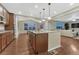 A lovely kitchen features hardwood floors, granite counters, pendant lights, and views into the adjacent living room at 7310 Blue Water Dr, Castle Rock, CO 80108