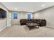 A roomy living room features a large leather sofa, neutral carpet, and a decorative coffee table at 7310 Blue Water Dr, Castle Rock, CO 80108