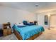 Bright bedroom featuring a bed with a blue comforter and adjacent wooden nightstand at 12504 E Cornell Ave # 103, Aurora, CO 80014
