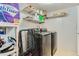 Efficient laundry room equipped with modern washer and dryer units and storage shelving at 12504 E Cornell Ave # 103, Aurora, CO 80014