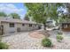 Spacious backyard featuring xeriscaping with rock and a large shade tree, ideal for outdoor living at 3272 S Joplin Ct, Aurora, CO 80013