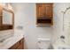 Bathroom featuring wooden cabinets, a sink, a toilet, and a stand-up shower at 3272 S Joplin Ct, Aurora, CO 80013