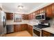 Updated kitchen with stainless steel appliances, wood cabinets, and hardwood floors at 3272 S Joplin Ct, Aurora, CO 80013