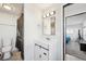 Clean bathroom featuring a vanity with white sink, a toilet, and a shower with a dark curtain at 1857 W Tennessee Ave, Denver, CO 80223