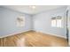 Empty bedroom featuring hardwood floors, two windows, and light blue walls at 1857 W Tennessee Ave, Denver, CO 80223