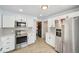 Well-lit kitchen equipped with stainless steel appliances and wood flooring, featuring ample storage space at 1857 W Tennessee Ave, Denver, CO 80223