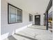 Covered porch with a black front door and a modern light fixture at 1857 W Tennessee Ave, Denver, CO 80223