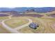 Aerial view of modern home nestled in scenic landscape with winding roads at 5741 Doc Bar Circle, Larkspur, CO 80118