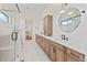 Bright bathroom featuring double vanity with white countertops and wood cabinets, plus a glass-enclosed shower at 5741 Doc Bar Circle, Larkspur, CO 80118
