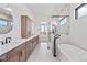 Bright bathroom with double sink vanity, soaking tub, and glass-enclosed shower at 5741 Doc Bar Circle, Larkspur, CO 80118