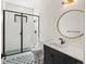 Modern bathroom displays a glass-enclosed shower, black hardware, and a decorative tile floor at 5741 Doc Bar Circle, Larkspur, CO 80118