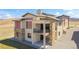 Expansive two-story home shows stone details, multiple windows, a balcony, and ample outdoor living space at 5741 Doc Bar Circle, Larkspur, CO 80118