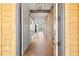 Stunning hallway displays hardwood floors, sliding barn doors, a brick accent wall, and stylish lighting fixtures at 5741 Doc Bar Circle, Larkspur, CO 80118