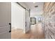 Hallway with light hardwood floors and brick accent wall at 5741 Doc Bar Circle, Larkspur, CO 80118