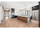 Spacious kitchen boasts an island, stainless steel appliances, modern lighting, and hardwood floors at 5741 Doc Bar Circle, Larkspur, CO 80118