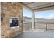 Covered patio with stone fireplace offering stunning views at 5741 Doc Bar Circle, Larkspur, CO 80118